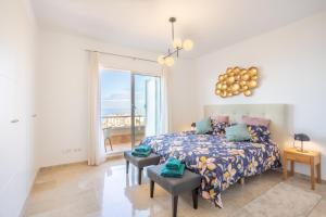 una camera con un letto e una grande finestra di Home2Book Sea View & Design Duplex Los Gigantes a Puerto de Santiago