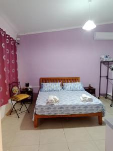 a bedroom with a bed and a purple wall at Casa vacanza Ligustro appartamento il gabbiano in SantʼAntìoco