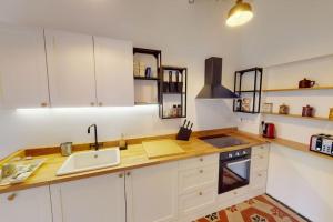 een keuken met witte kasten en een wastafel bij Narrow Street Suite in Victoria