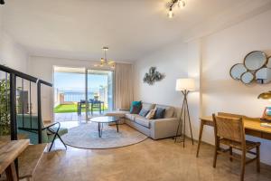 un soggiorno con divano e tavolo di Home2Book Sea View & Design Duplex Los Gigantes a Puerto de Santiago