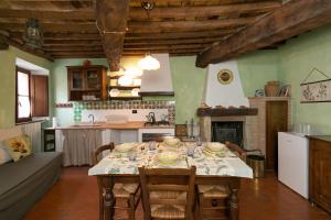 a kitchen with a table and chairs and a kitchen with a fireplace at Il Mirtillo in Pisa