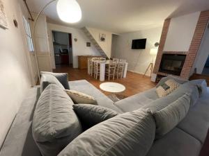 ein Wohnzimmer mit einem grauen Sofa und ein Wohnzimmer mit einem Tisch in der Unterkunft Lauraguel Gîte in Mourvilles-Hautes