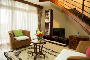 a living room with two chairs and a television at Hotel Safari Gate in Bujumbura