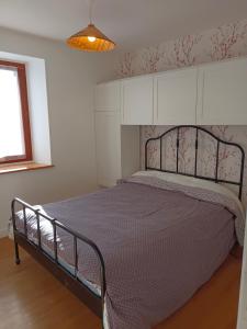 een slaapkamer met een bed met een paarse deken bij Gîtes de Voingt 