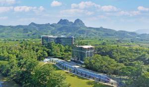 a train on a track with mountains in the background at MEDDOM Park in Cao Phong