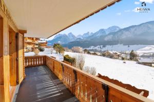 a balcony with a view of snow covered mountains at Logement spacieux et confortable in Chateau-d'Oex