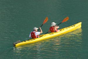 2 personnes dans un kayak jaune dans l'eau dans l'établissement Indochina Sails Ha Long Bay Powered by ASTON, à Hạ Long