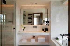 a bathroom with a sink and a mirror at Dusit Suites Athens in Athens