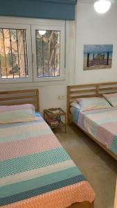 2 camas en una habitación con 2 ventanas en Appartement la Cala de Mijas toegang tot strand, en Mijas