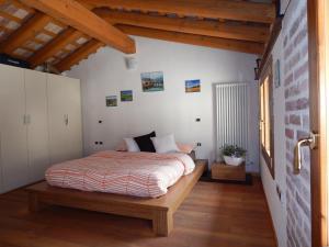 羅馬諾德恩佐利諾的住宿－Monte Grappa Guest House，铺有木地板的客房内设有一间卧室和一张床。