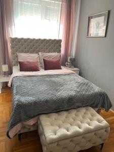 a bedroom with a large bed with a tufted headboard at bona loca in Smederevska Palanka