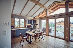 a kitchen and dining room with a table and chairs at Kittenberger Chalets am Gartensee in Schiltern