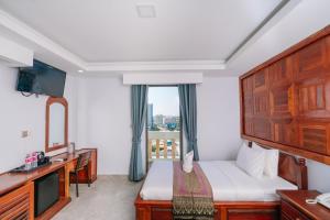 a hotel room with a bed and a television at V CROWN HOTEL in Battambang +18 photos