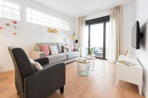 uma sala de estar com um sofá e uma mesa em Apartamento con jardin privado y portero (A) em Madri