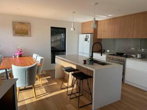 a kitchen with a counter and a table and a dining room at New, Contemporary, Well Appointed, Beach House in Kingston Beach