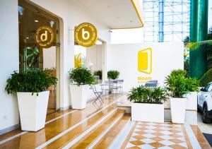 un hall d'un magasin avec des plantes en pot dans l'établissement Bloom Hotel - Bengaluru Airport, à Devanhalli