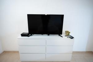 A television and/or entertainment centre at PORT CITY HAIFA - Downtown Studio with Gallery nxt German Colony