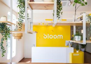 a store with a yellow wall with the sign sloan at Bloom Hotel - Bengaluru Airport in Devanhalli