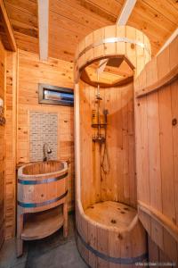 ein Holzbadezimmer mit einer Holzbadewanne in einer Hütte in der Unterkunft Rita Art Chalet Voronet in Voroneţ