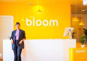 a woman standing in front of a yellow wall at Bloom Hotel - Bengaluru Airport in Devanhalli