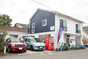 Destiny Inn Sakaiminato في ساكايميناتو: سيارتين متوقفتين أمام محطة وقود