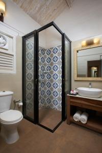 a bathroom with a toilet and a sink and a mirror at Larisa Beach Resort in Morjim