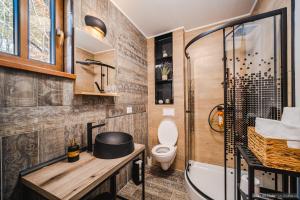 a bathroom with a tub and a toilet and a shower at Rita Art Chalet Voronet in Voroneţ