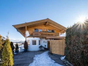 uma casa com um telhado de madeira com neve no chão em Ferienhaus Willms am Gaisberg em Kirchberg in Tirol