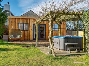 une maison avec un bain à remous dans la cour dans l'établissement Log Cabin near Bath, à Chippenham