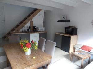 a living room with a wooden table and a kitchen at Casa di Ceppo in Patrimonio