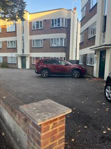 a red car parked in a parking lot in front of a building at Castle Court Apartment in London