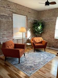 ein Wohnzimmer mit 2 Stühlen und einem Teppich in der Unterkunft Brick Street Apartment-Studio Suite in Augusta