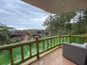 a balcony with a green railing and a chair on a balcony at 2nd Floor- 3BR camp John Hay Unit For Rent in Baguio
