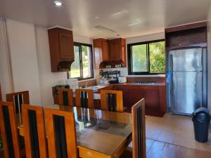 a kitchen with a table and chairs and a refrigerator at 2nd Floor- 3BR camp John Hay Unit For Rent in Baguio