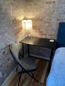 einen Schreibtisch mit einer Lampe und einem Stuhl in einem Zimmer in der Unterkunft Brick Street Apartment-Studio Suite in Augusta