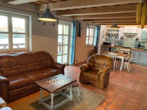 a living room with a couch and chairs and a kitchen at Kopanický dvor in Hodruša