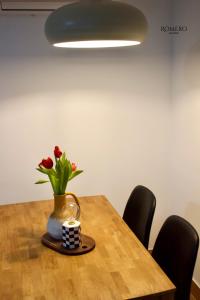 Romero Suites 1 في قرطبة: طاولة مع إناء من الزهور وشمعة