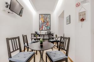 a dining room with tables and chairs and a tv at Vatican City Guest House in Rome