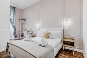 a white bedroom with a large white bed with white pillows at Vatican City Guest House in Rome