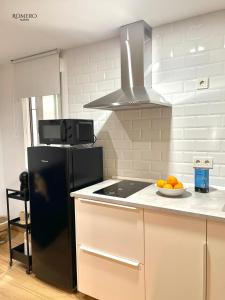 una cocina con nevera negra y un tazón de naranjas en Romero Suites 1, en Córdoba