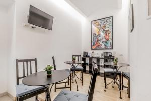 a living room with tables and chairs and a flat screen tv at Vatican City Guest House in Rome