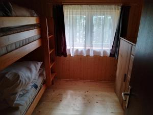 Zimmer mit 2 Etagenbetten und einem Fenster in der Unterkunft Hütte Waldesruh in Kaltenberg