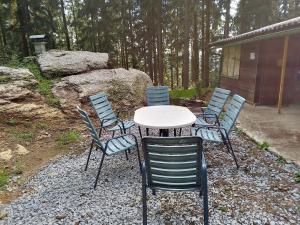 un tavolo e sedie seduti su un patio di ghiaia di Hütte Waldesruh a Kaltenberg