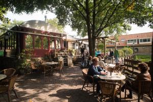 un grupo de personas sentadas en mesas en un restaurante en Buitengoed De Uylenburg, en Delft