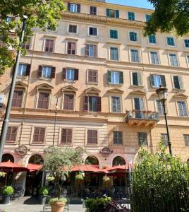 un grand bâtiment avec des parasols rouges devant lui dans l'établissement Largo Leopardi apartment, à Rome
