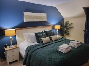 een slaapkamer met een groot bed met een blauwe muur bij Avalon in Inverness