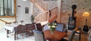 a dining room with a table and chairs and a staircase at Chambres d'hôtes dessine-moi un chemin in Sauvelade