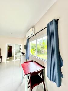 Pokój z czerwonym stołem i oknem w obiekcie Lay Back Villa C1with kitchen & High Speed Internet w mieście Krabi