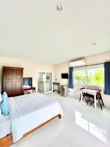 a bedroom with a large bed and a table at Lay Back Villa C1with kitchen & High Speed Internet in Krabi town