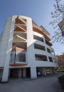 een tallartment gebouw met een parkeerplaats bij Elia mini suites 6 in Larisa